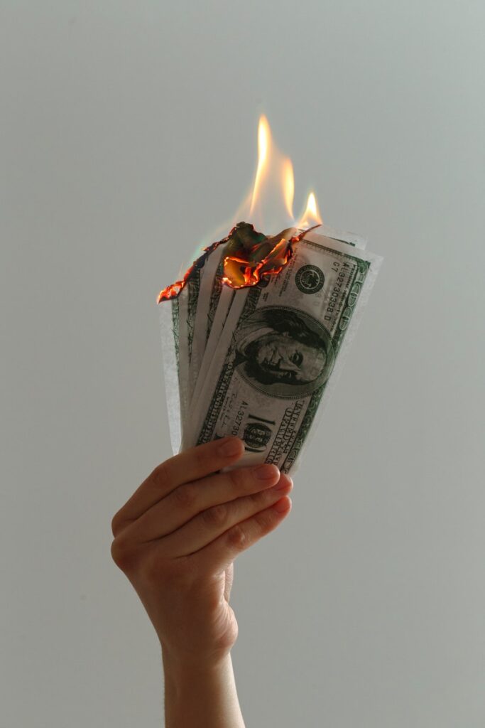 time lapse photography of several burning US dollar banknotes