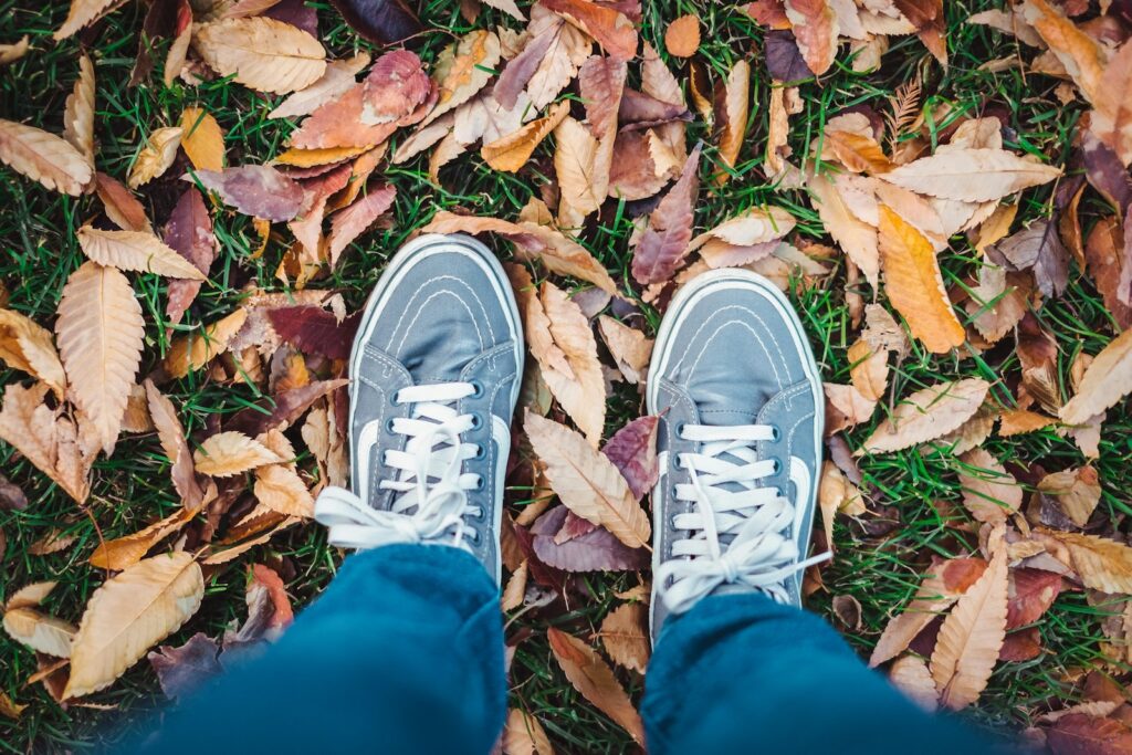 person standing on dried leaves outdoors