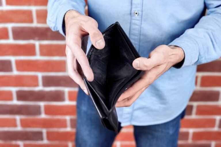 man-wearing-blue-shirt-showing-empty-black-wallet_1268-14494