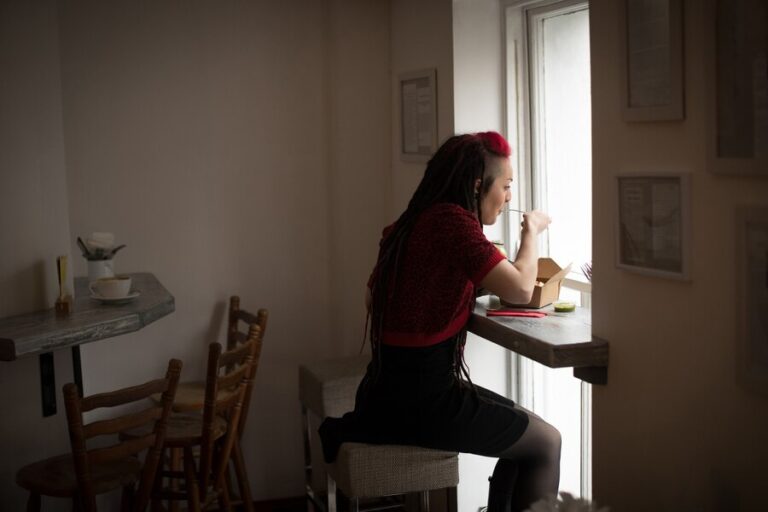 woman-looking-through-window-while-having-salad_107420-96459