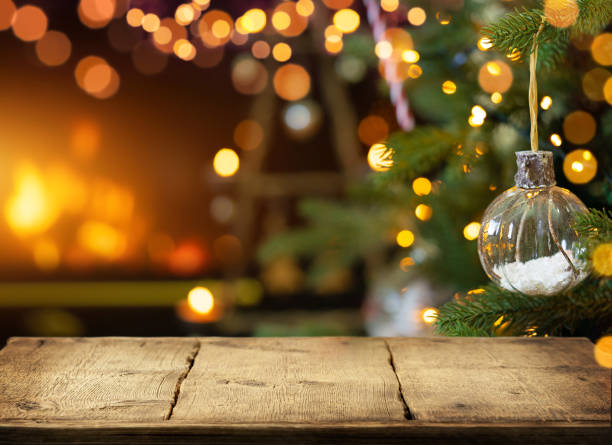 Empty wooden table on Christmas ornaments background with fireplace