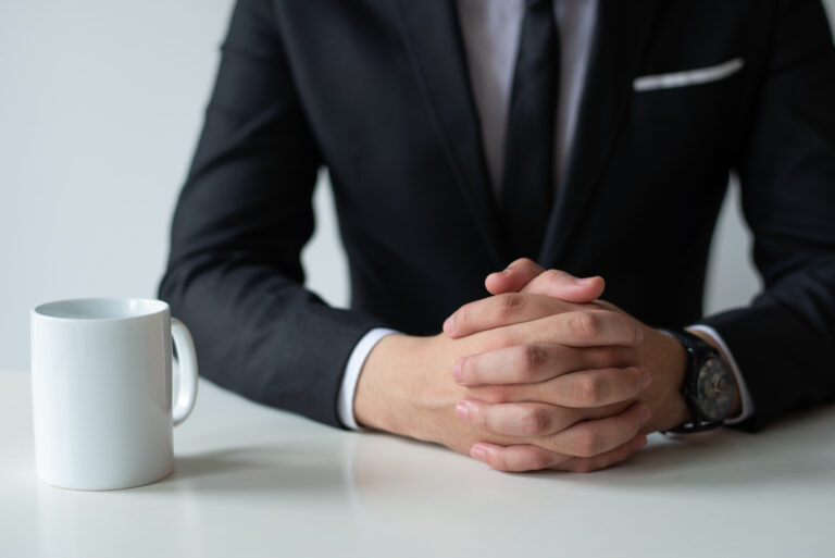 Closeup of thoughtful entrepreneur with clasped hands